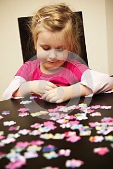 Girl playing with jigsaw puzzle