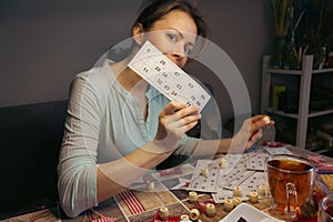 Girl playing in lotto. Nostalgia lifestyle. Woman playing bingo and holding card. Win concept. Leisure activity