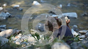 Girl Playing at Mountain River at Camping, Tourist Child Throwing Stones in Stream Water, Kid Outdoor in Trip, Children in Nature