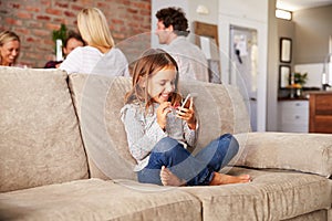 Girl playing with new technology while adults entertain