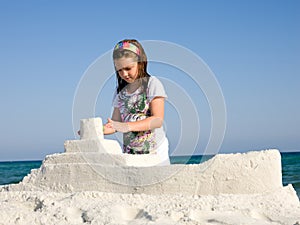 Girl playing by ocean sculpturing boat