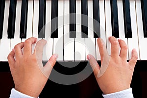 Girl playing piano. Closeup hands, top view. Art and music background. Concept of practice and education basic of music.