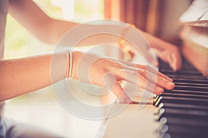 Girl is playing piano at home, high angle view, blurry background