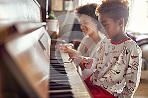 Girl is playing on piano x-mas music. Concept Christmas, New Year, holiday, family happiness, childhood
