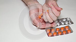 Girl playing with pills and two blisters with medicine on the table