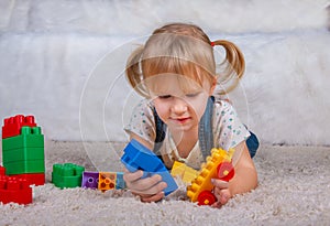 Girl playing with plastic toys cubes constructions