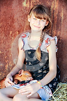 The girl is playing with red newborn pigs of the Duroc breed. The concept of caring and caring for animals
