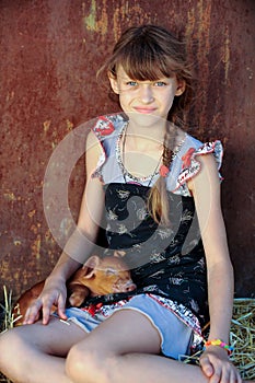 The girl is playing with red newborn pigs of the Duroc breed. The concept of caring and caring for animals