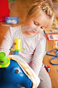 Girl playing with rubber donkey toy