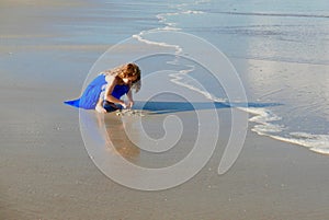 Girl playing in the sand on the beach