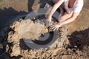 Girl playing in the sand on the lake