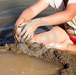 Girl playing in the sand on the lake