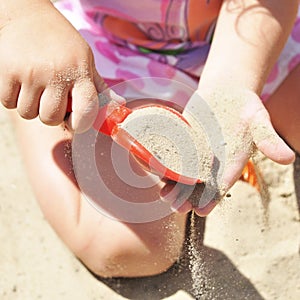 Girl playing with sand in a sandbox