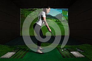 A girl playing screen golf. Golf Simulator. photo