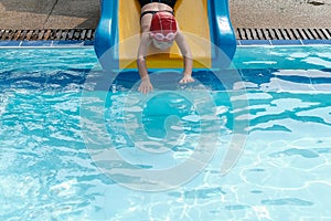 a girl playing slider in swimmimg pool
