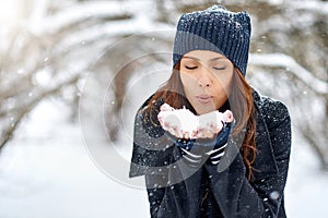 Girl playing with snow in park - close up portrait. Copy space