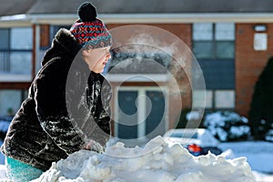 Girl playing with snow. Steam comes from the mouth