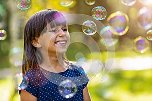 Girl playing with soap bubbles outdoors