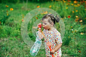 Girl playing with soap bubbles in the Park