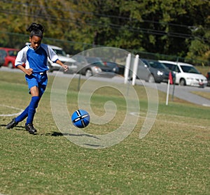 Girl playing soccer with focus