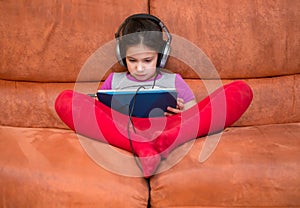 Girl playing tablet pc with headphones