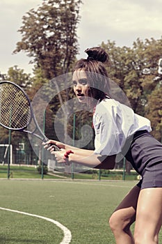Girl playing tennis on green court
