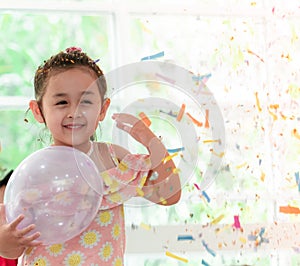 Girl playing and throwing paper in kid party