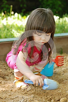 The girl playing to a sandbox