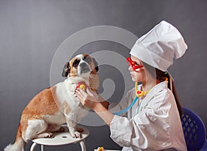 Girl playing veterinarian with dog