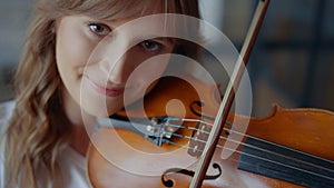 Girl playing violin with bow. Musician performing musical composition on violin