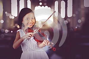 Girl playing violin while looking and smiling