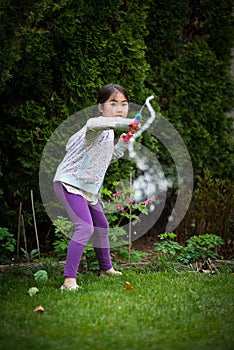 Girl playing with water gun in backyard in summer