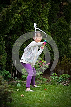 Girl playing with water gun in backyard in summer