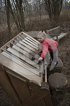 Girl playing a xylophone in a garden
