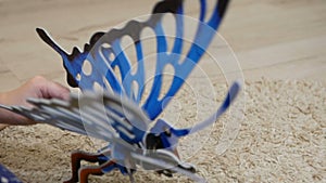 Girl plays with 3d puzzle of butterfly