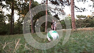 Girl plays ball in a forest glade