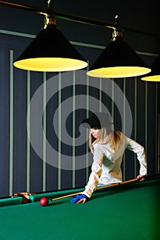 The girl plays billiards