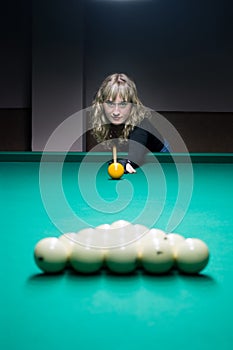 The girl plays billiards