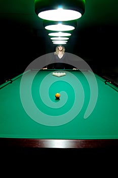 The girl plays billiards