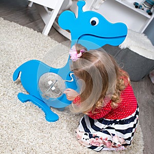 Girl plays with a blue piggy Bank