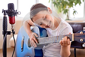 girl plays on guitar, adorable kid in casual wear learning to play musical instrument
