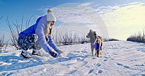 A girl plays with her dog on a walk.