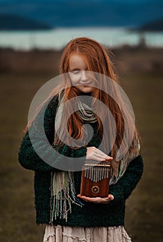 The girl plays the kalimba. Percussion instrument.