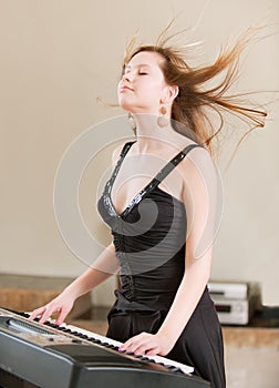 Girl plays keyboard synthesizer