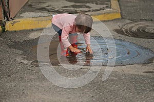 Girl plays in the puddle outdoors