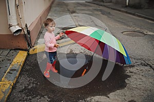 Girl plays in the puddle outdoors