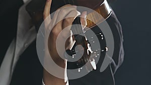 Girl plays the violin a composition in a dark smoky room. Close up