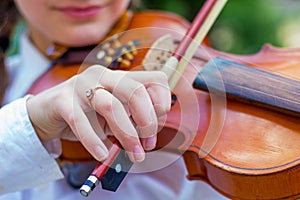 The girl plays the violin, the girl`s hand with fiddle bow_