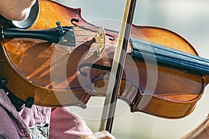 Girl plays the violin on the street of a modern city. Street musician