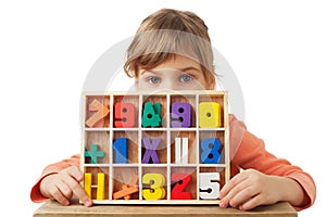 Girl plays in wooden figures in form of numerals photo